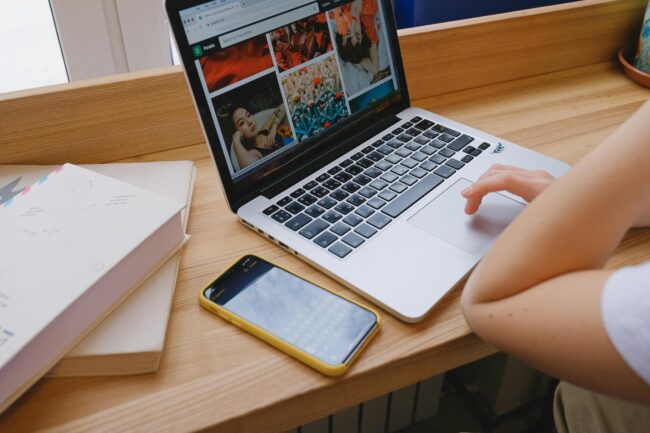 A person using laptop on brown wooden table